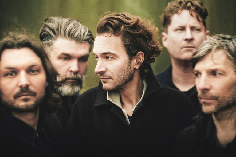 English rock band Editors close-up group portrait shot by photographer Rahi Rezvani, featuring frontman Tom Smith in profile looking right.